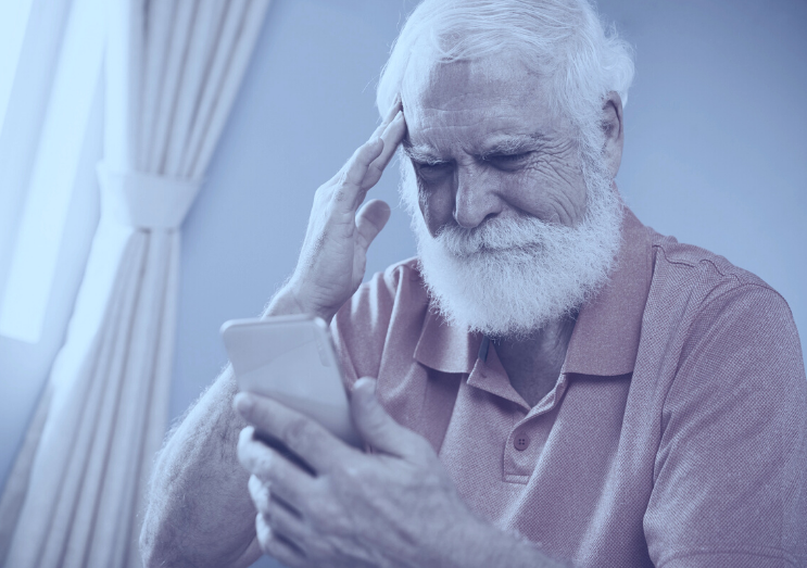 old man looking at a phone looking anxious